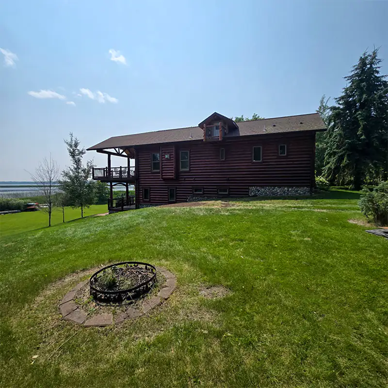 Open, cleared lawn beside a Northern Minnesota lake home after WoodChucks finished the tree work